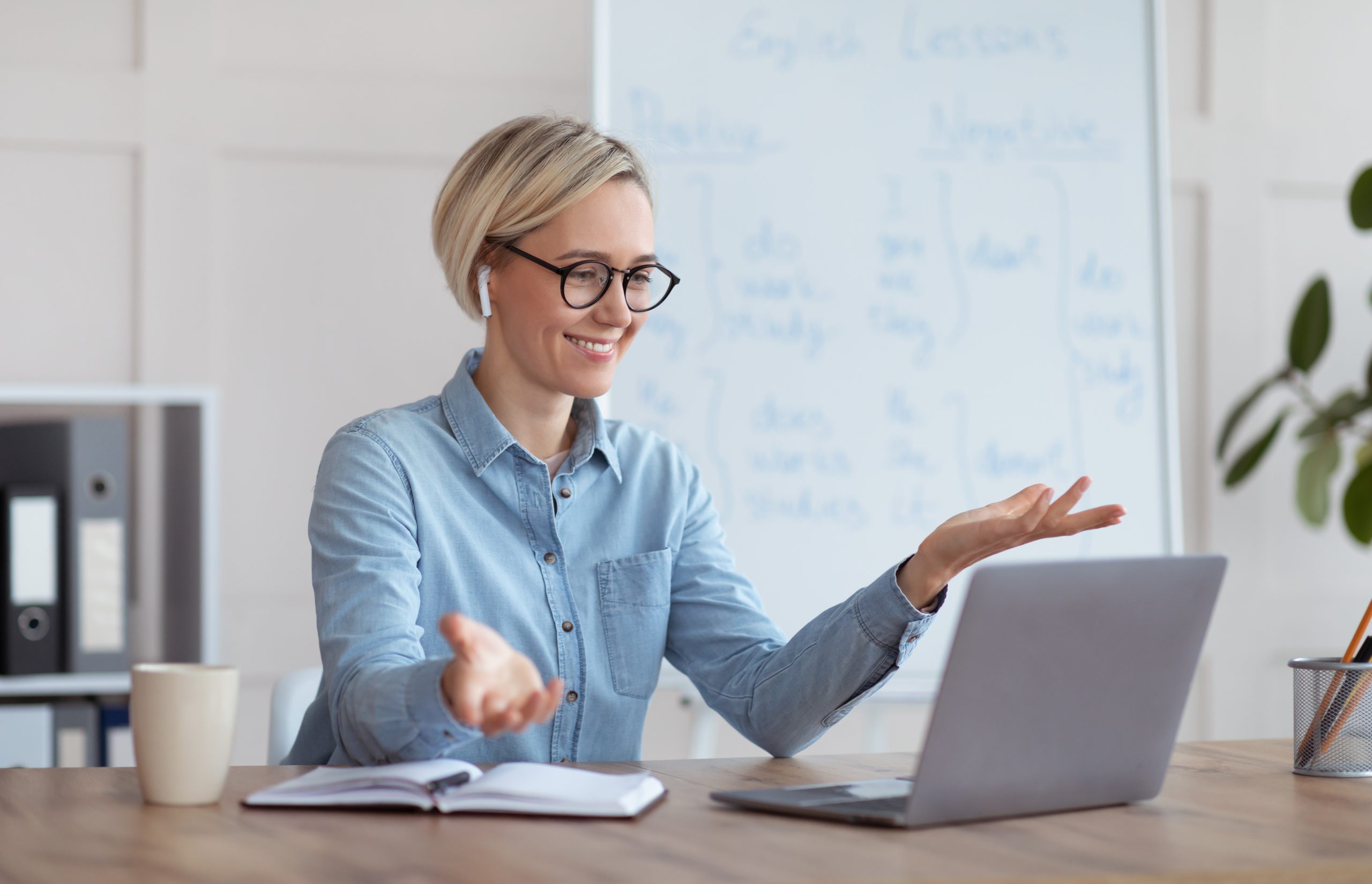 Experienced English teacher giving online lesson on laptop, chatting with students, participating in webinar from home Experienced English teacher giving online lesson on laptop, chatting with students, participating in webinar from home. Languages school tutor explaining grammar to pupils on internet